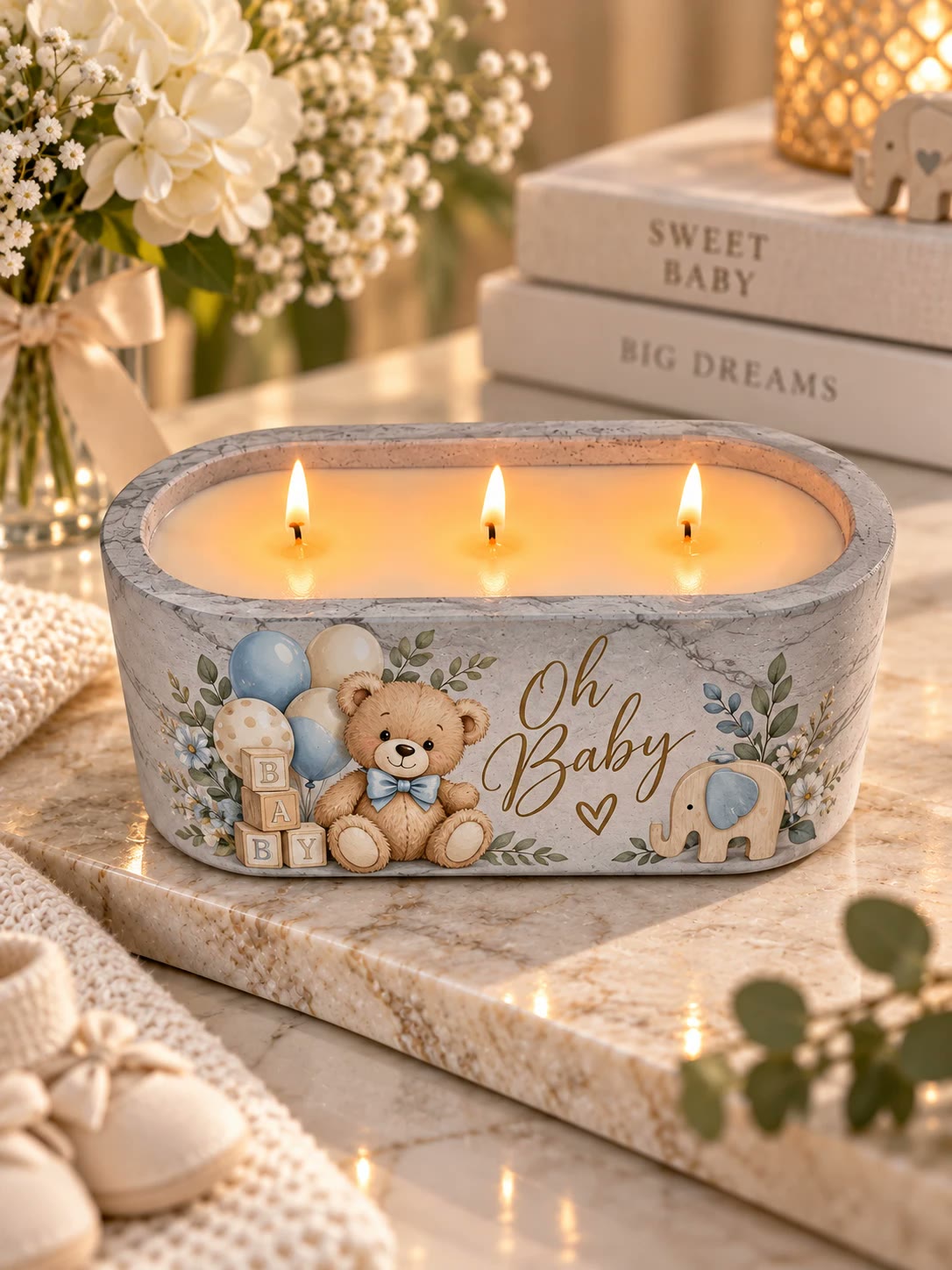 Marbled candle with three lit wicks, a teddy bear with balloons, and the words Oh Baby in gold script.