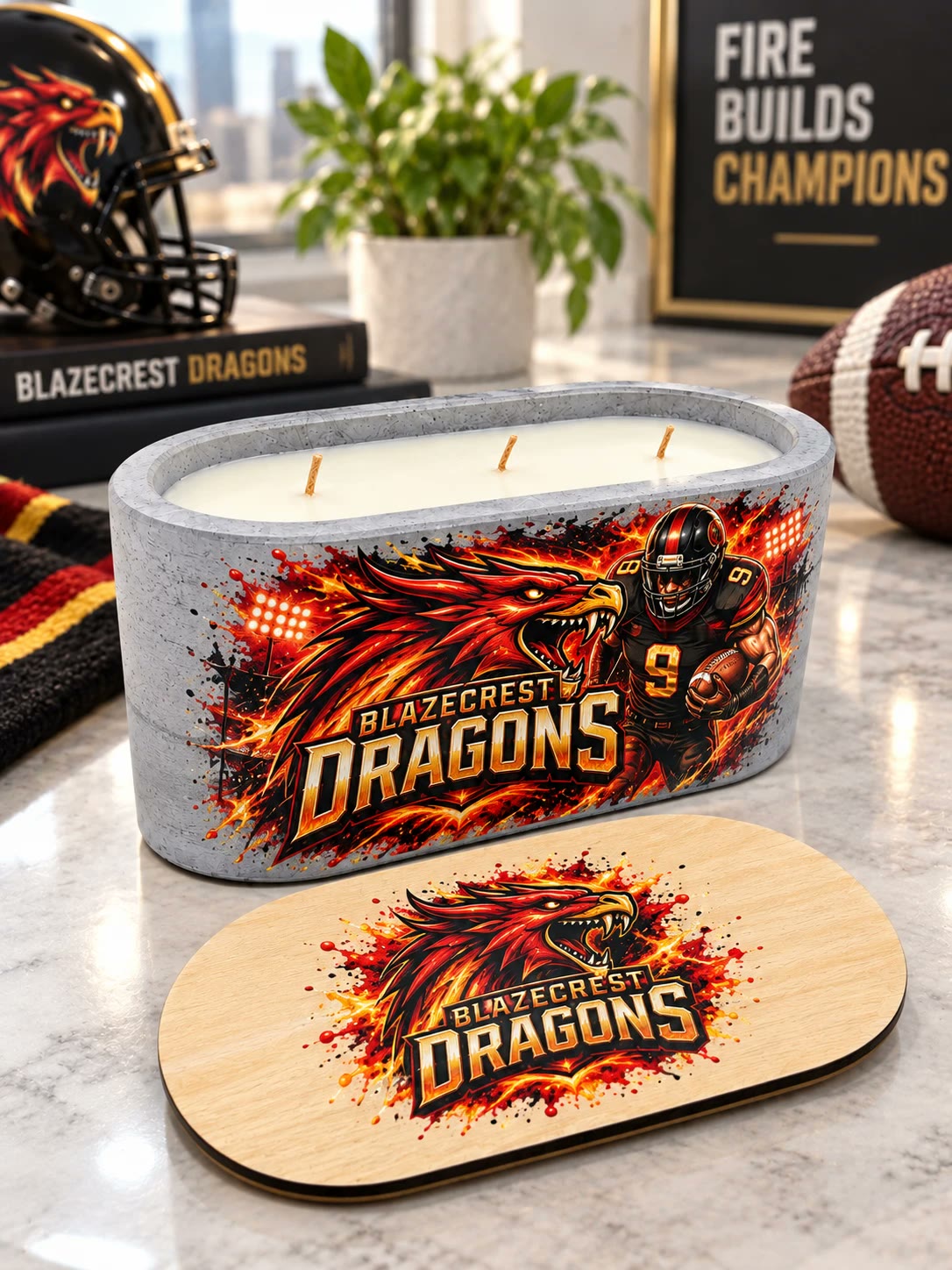 Concrete candle wrapped in red and gold art of a dragon mascot and a football player, the matching Blazecrest Dragons lid lying in front.